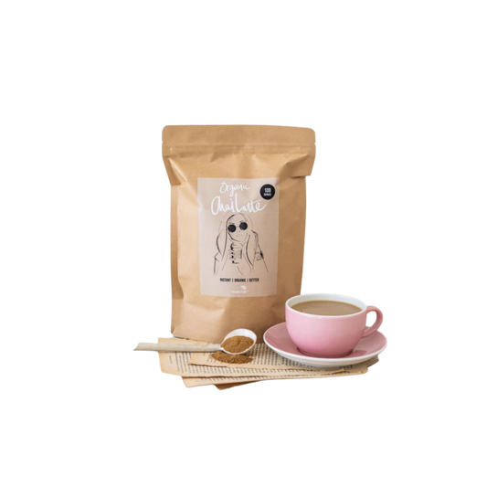 Chai bag with a pink cup of chai latte and spoon 